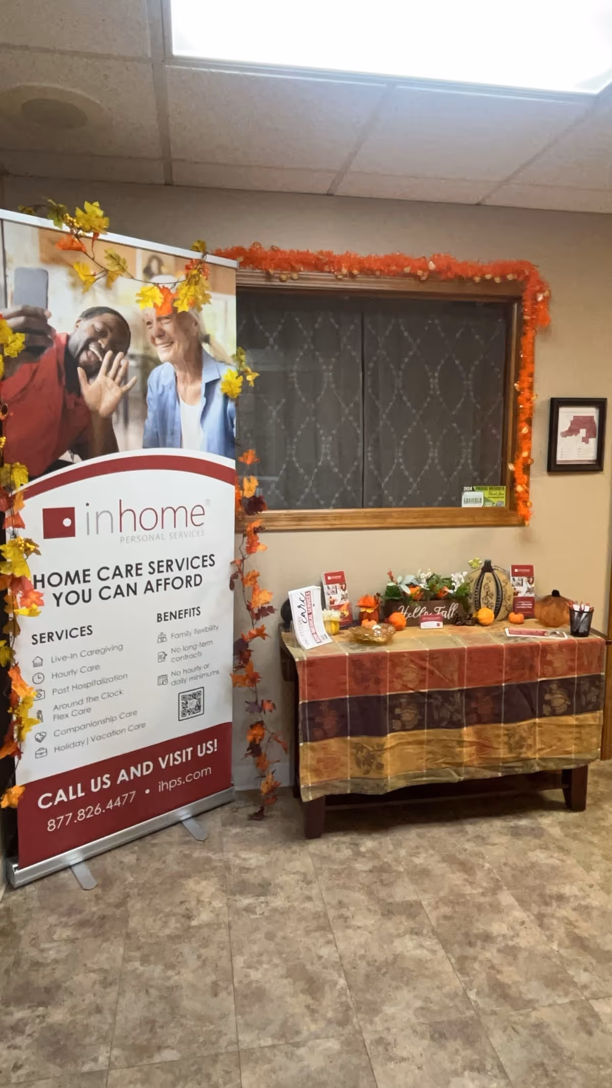 Indoor promotional display with an in home personal services banner beside a decorated table.