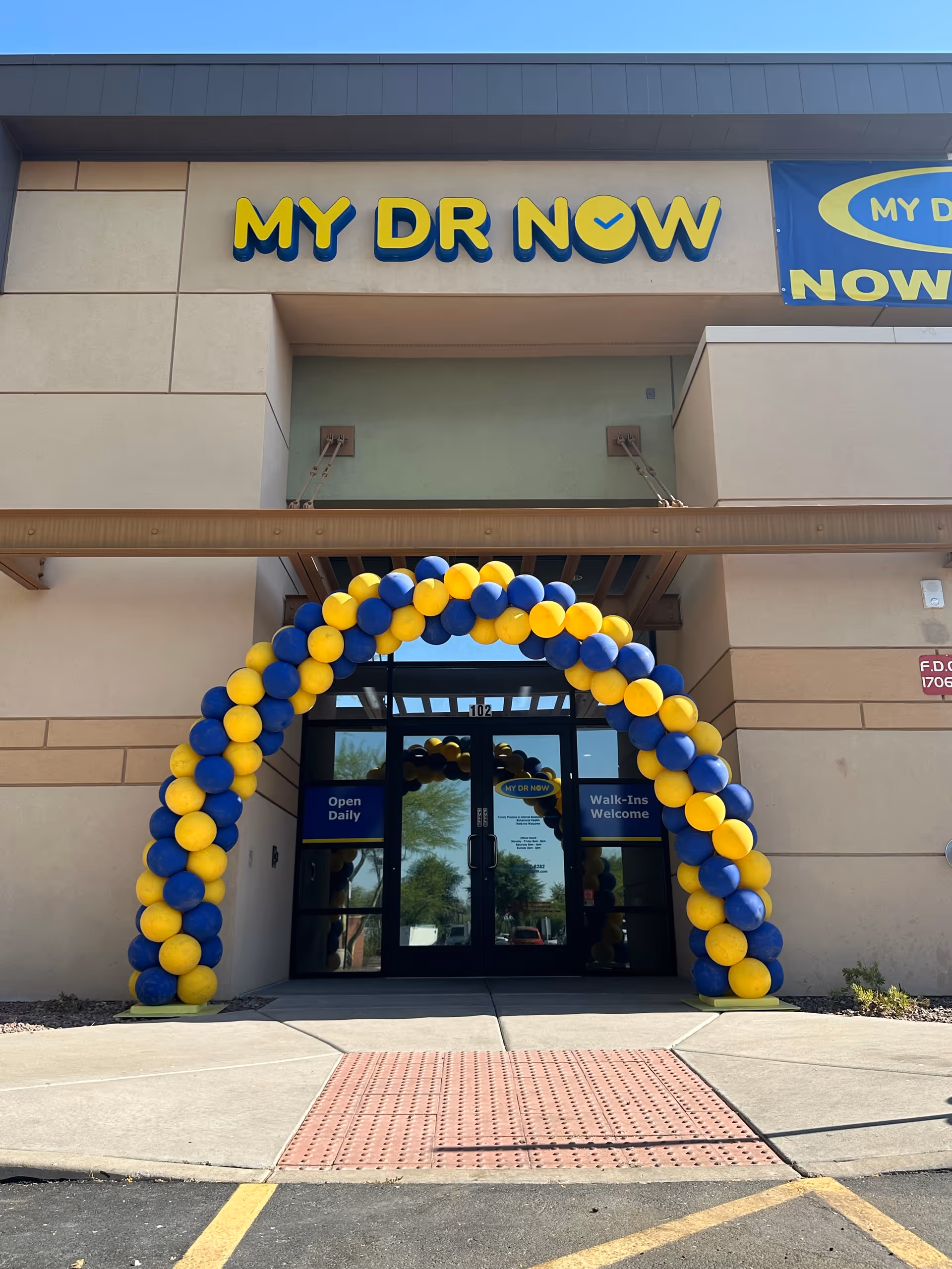 Exterior view of MY DR NOW facility entrance with a balloon arch