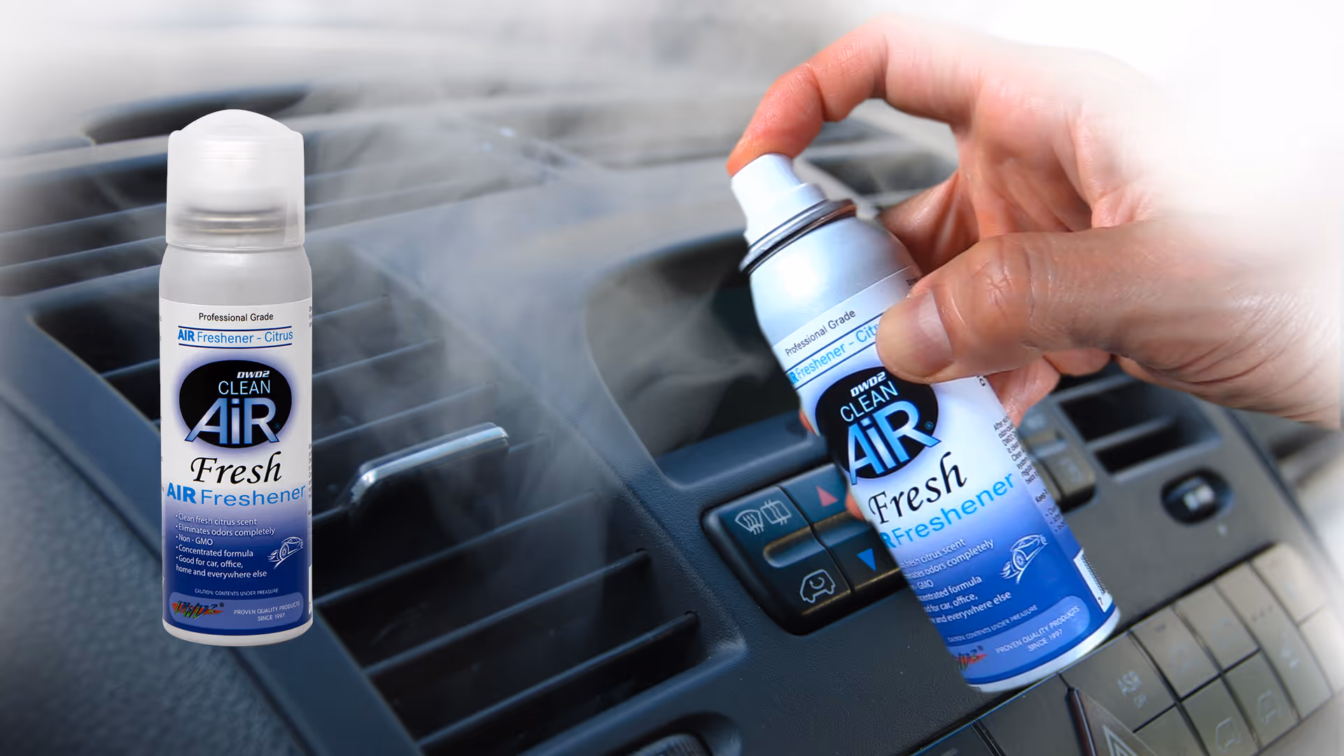 A hand holds a blue air freshener spray near a car dashboard vent.