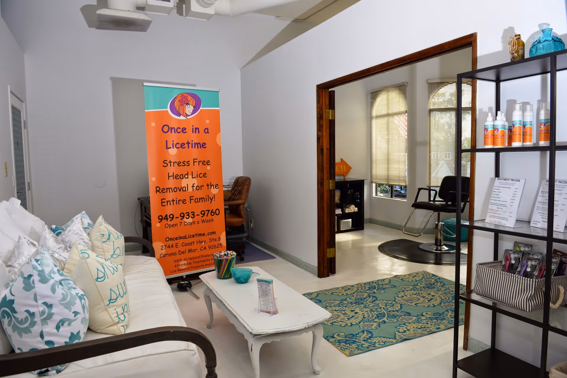 Bright interior lobby with a banner, couch, rug, and product shelves.