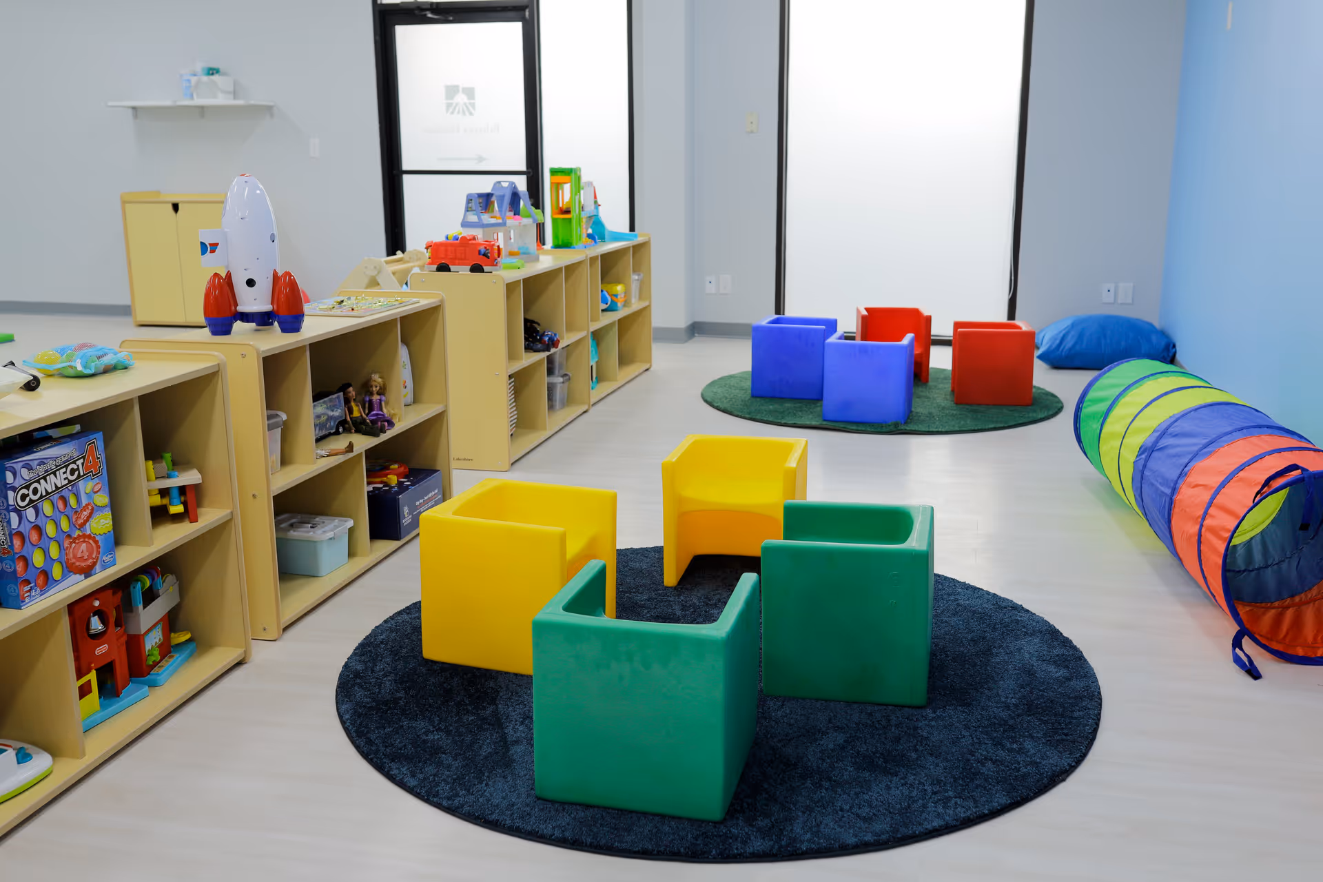 Bright playroom at Behavior Frontiers Autism Center with colorful seating and toy shelves.