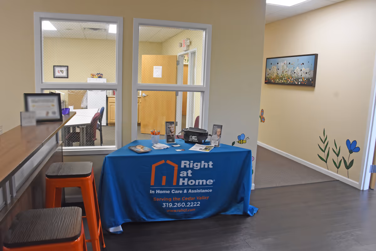 Interior reception area with a blue Right at Home information table and wall artwork.