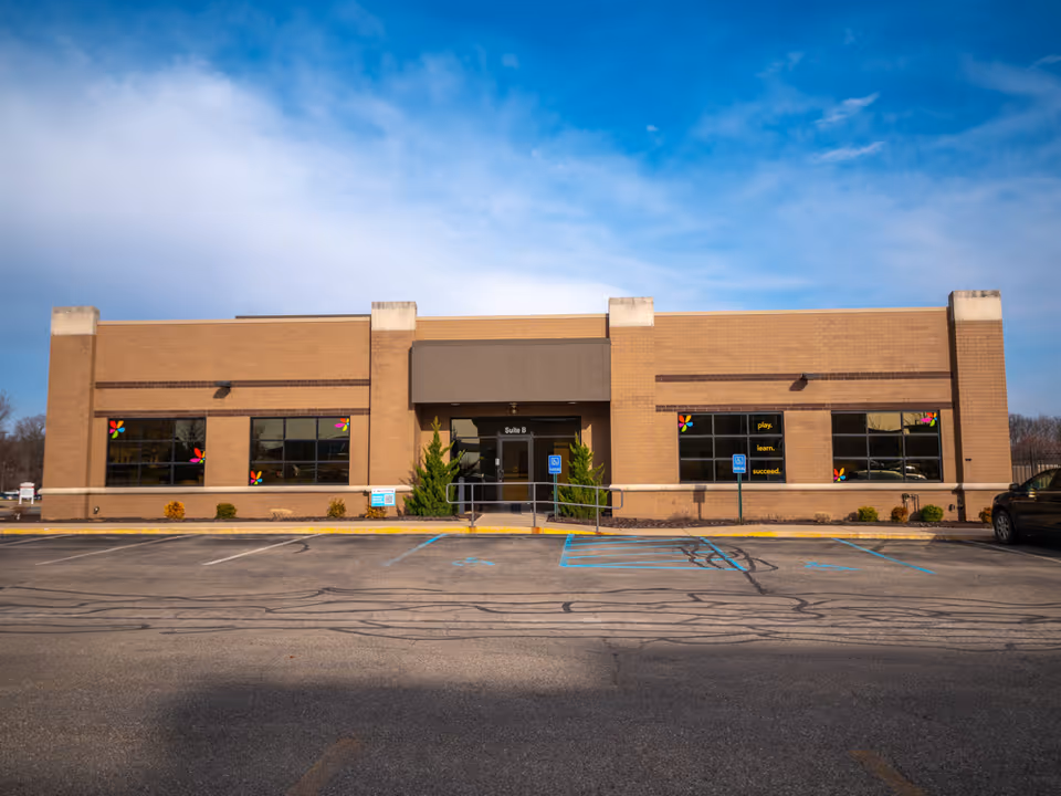 Exterior view of Total Spectrum ABA building with brick facade, large windows, and front parking.