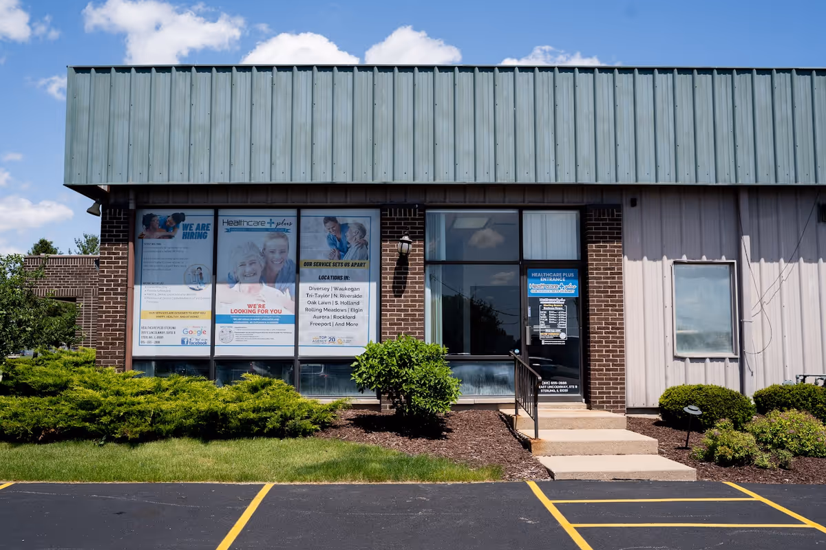 Exterior view of a Healthcare Plus Caregivers facility with entrance and signage.