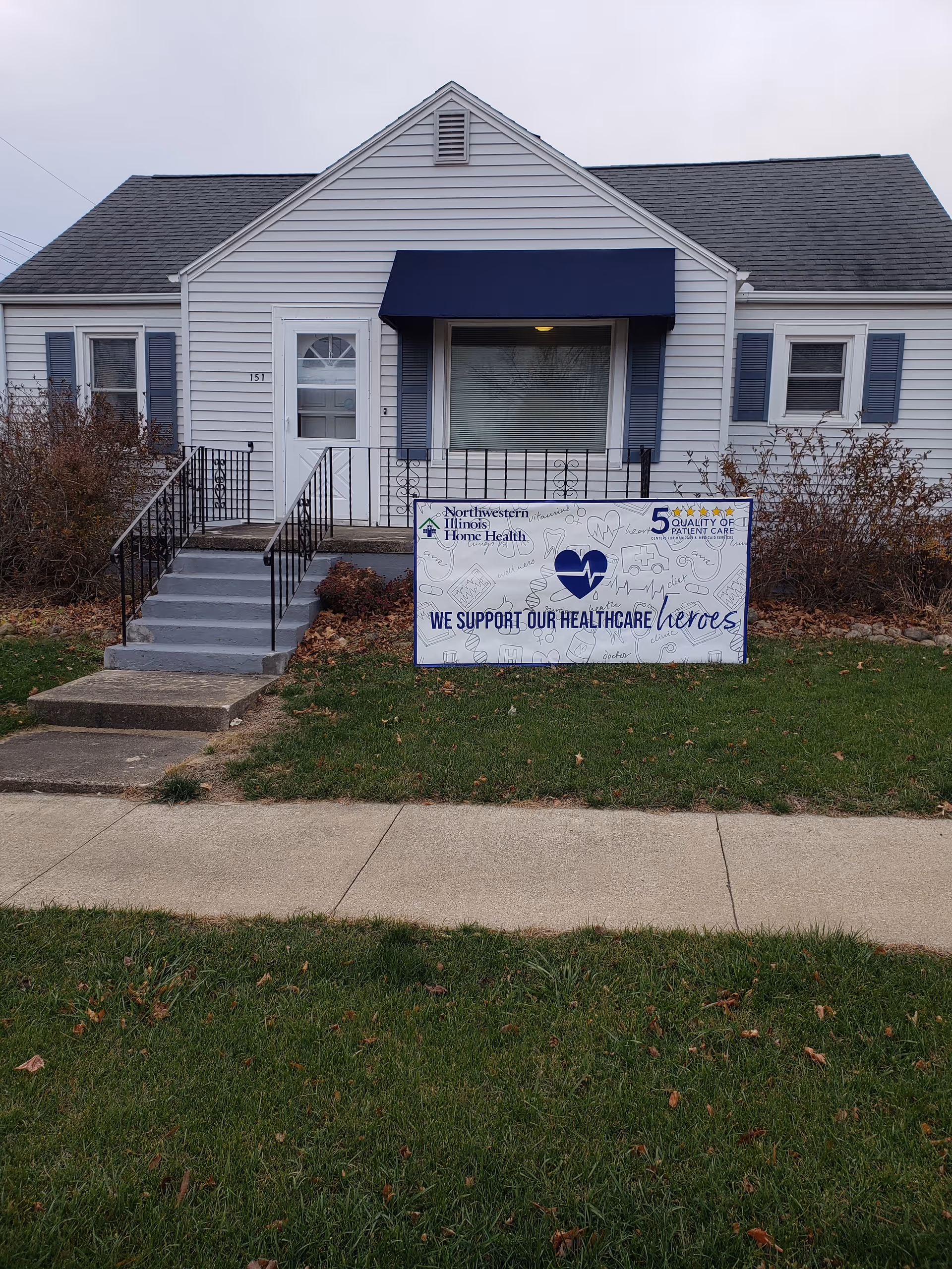 Front view of a single-story home health facility with a blue awning and sign.
