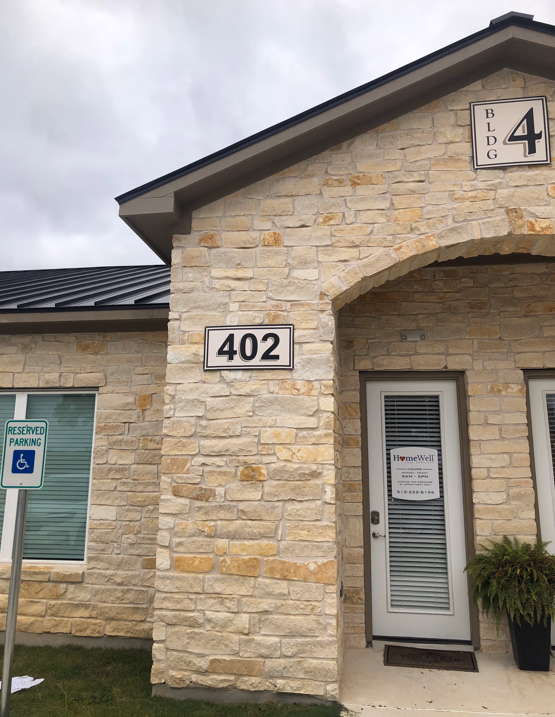 Stone facade building front with 402 sign and HomeWell door.