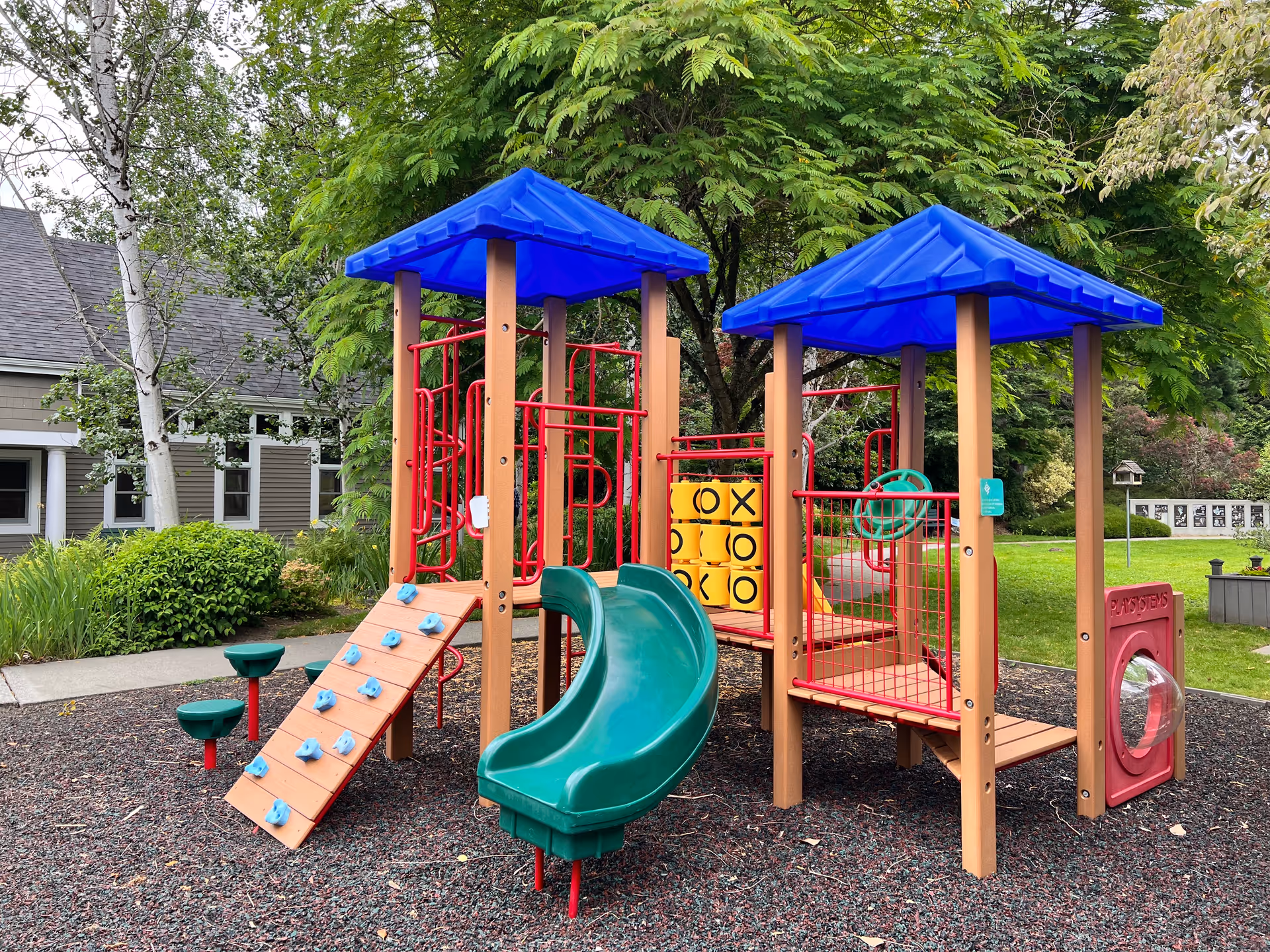 Colorful outdoor playground structure with slides and climbing features in the facility grounds.
