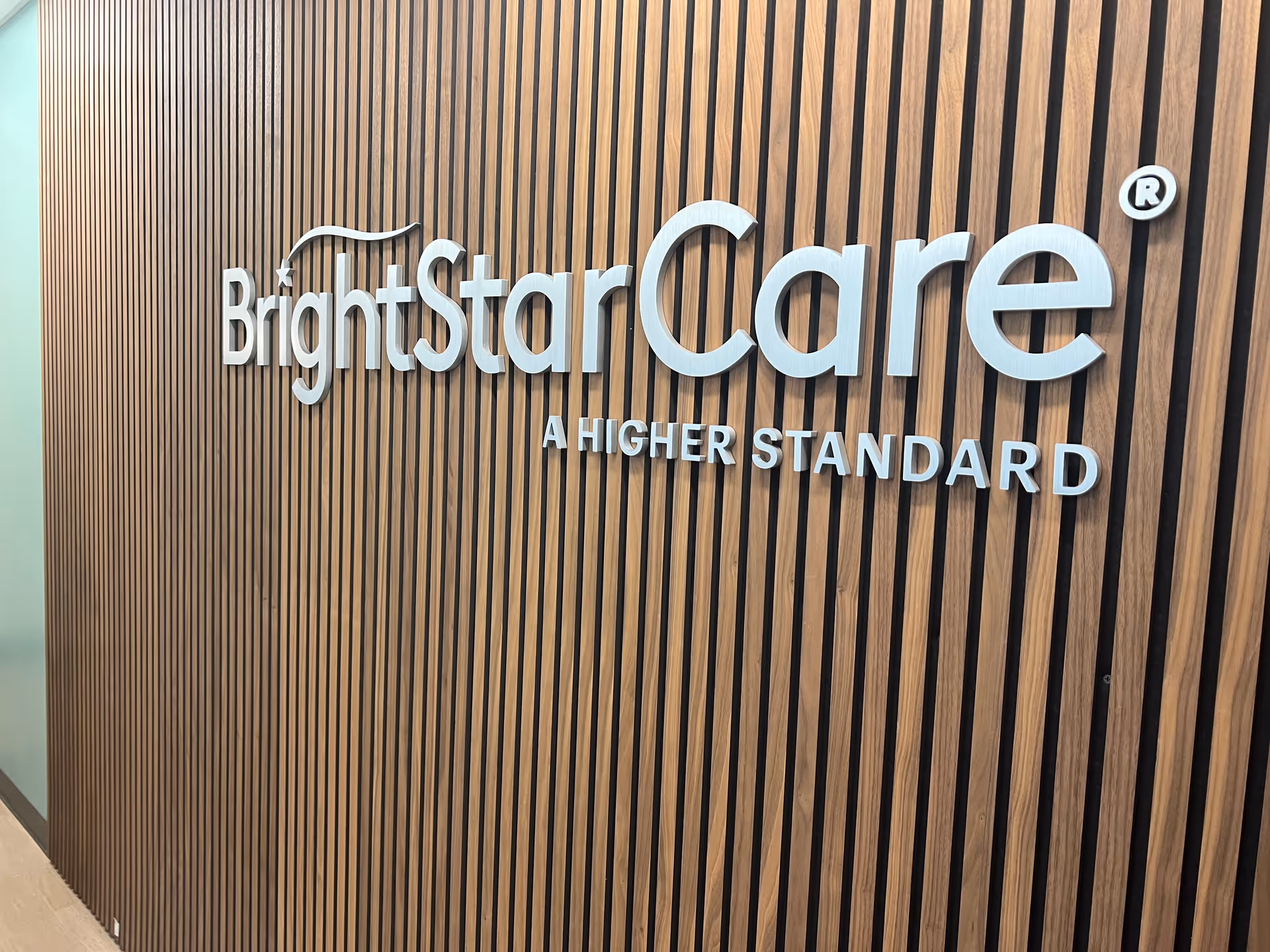 Interior wall with BrightStarCare sign on vertical wooden slats.