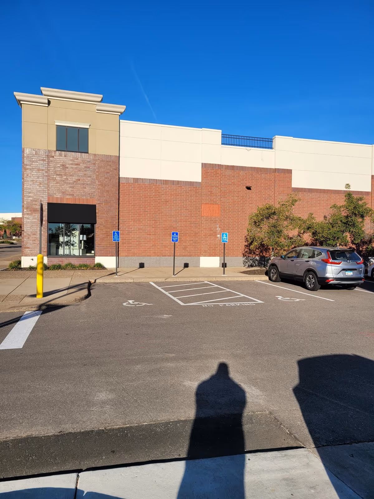 Exterior view of a modern senior care facility with parking and accessible spaces.