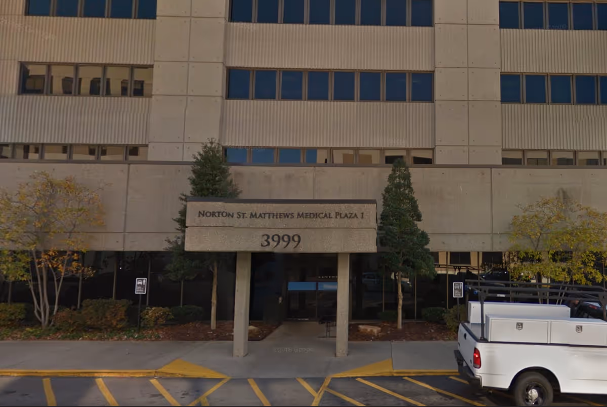 Exterior of Norton St. Matthews Medical Plaza 1 with entry, sign, trees, and a white truck.