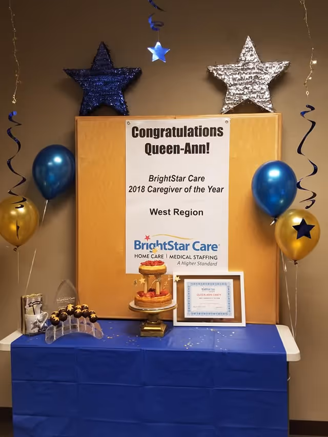 Award display with cake, balloons, and a BrightStar Care banner in a decorated room.