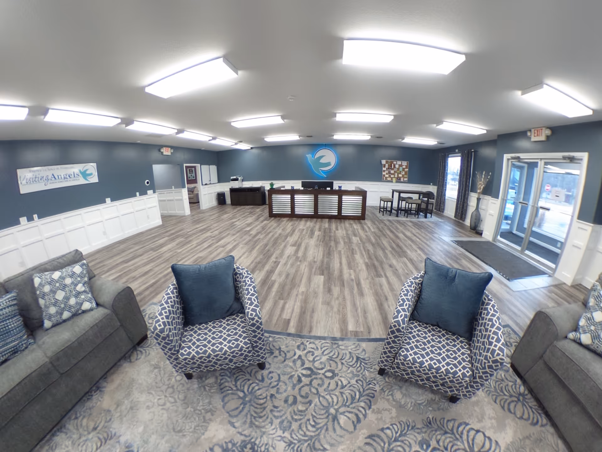 Spacious lobby with couches, chairs, and a central reception desk.