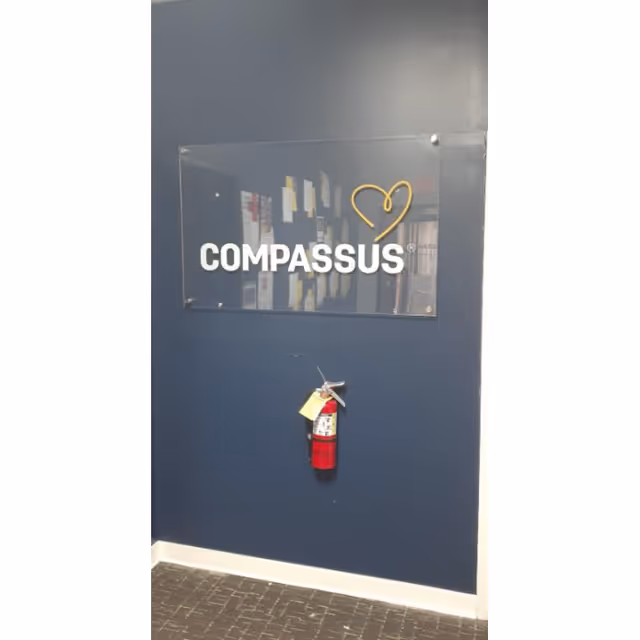 Blue interior wall with a Compassus sign and a fire extinguisher.