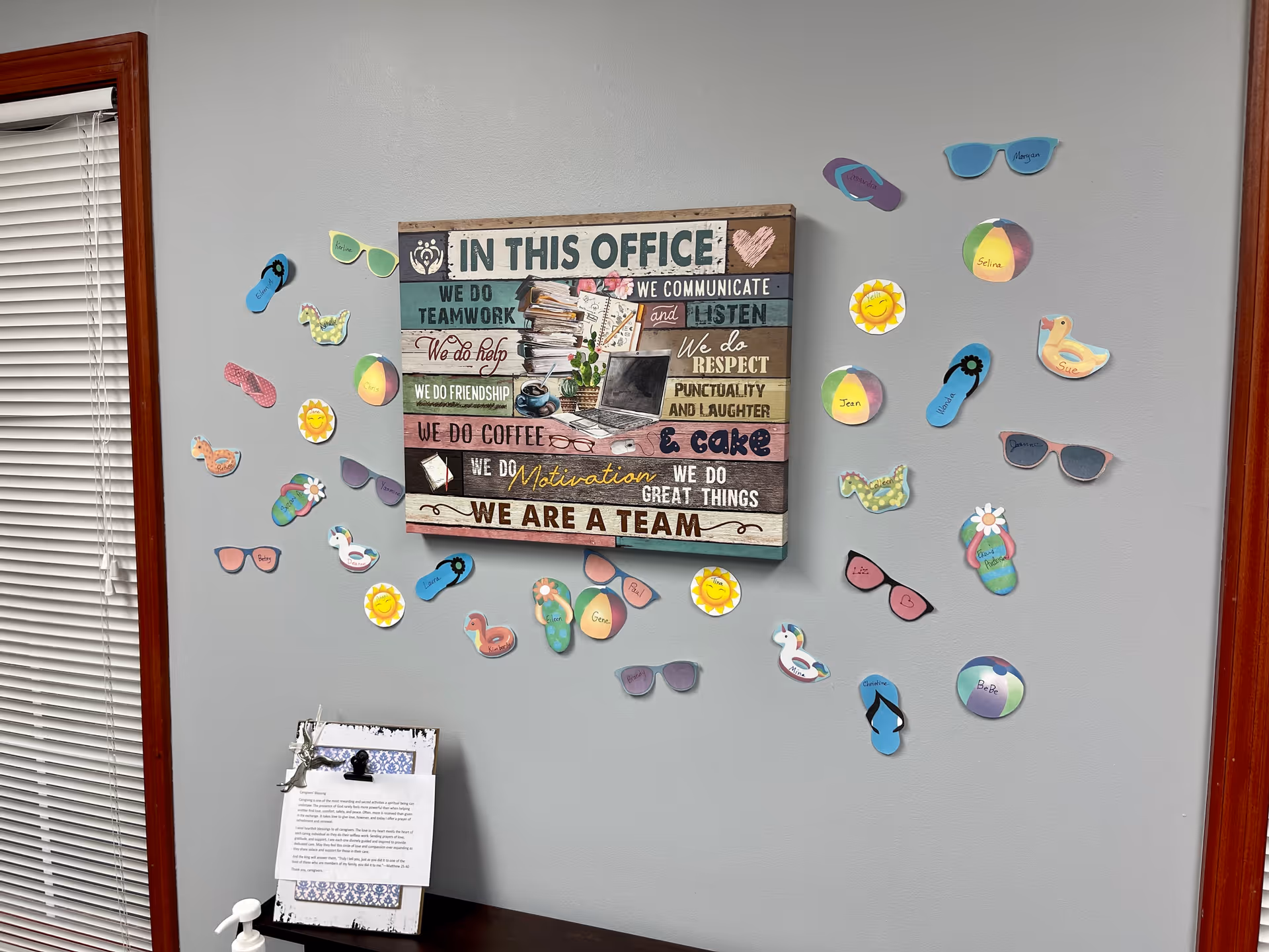 Office wall with colorful sunglasses cutouts and a large 'In This Office' sign.