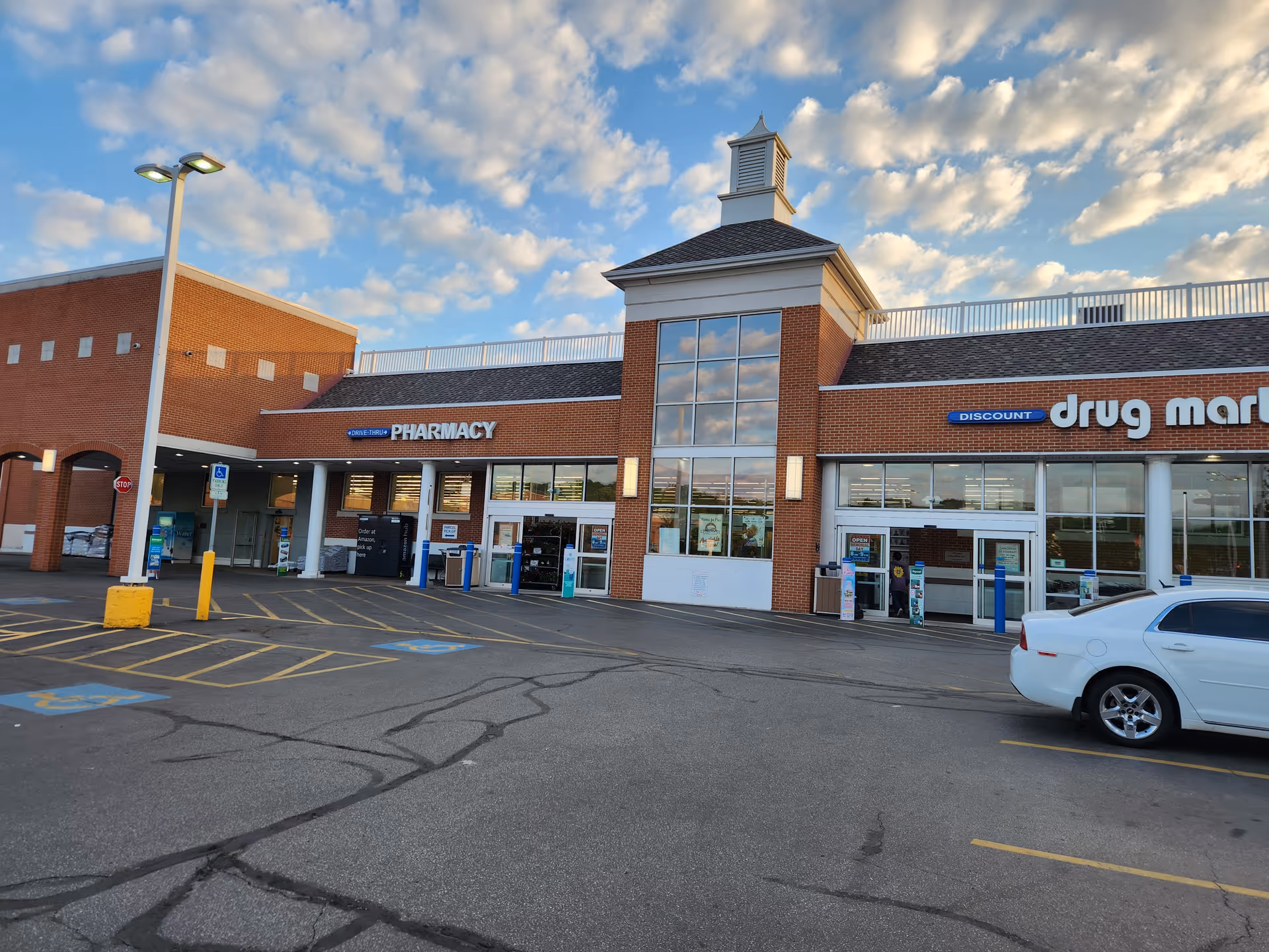 Exterior view of Discount Drug Mart storefront in a brick shopping plaza.