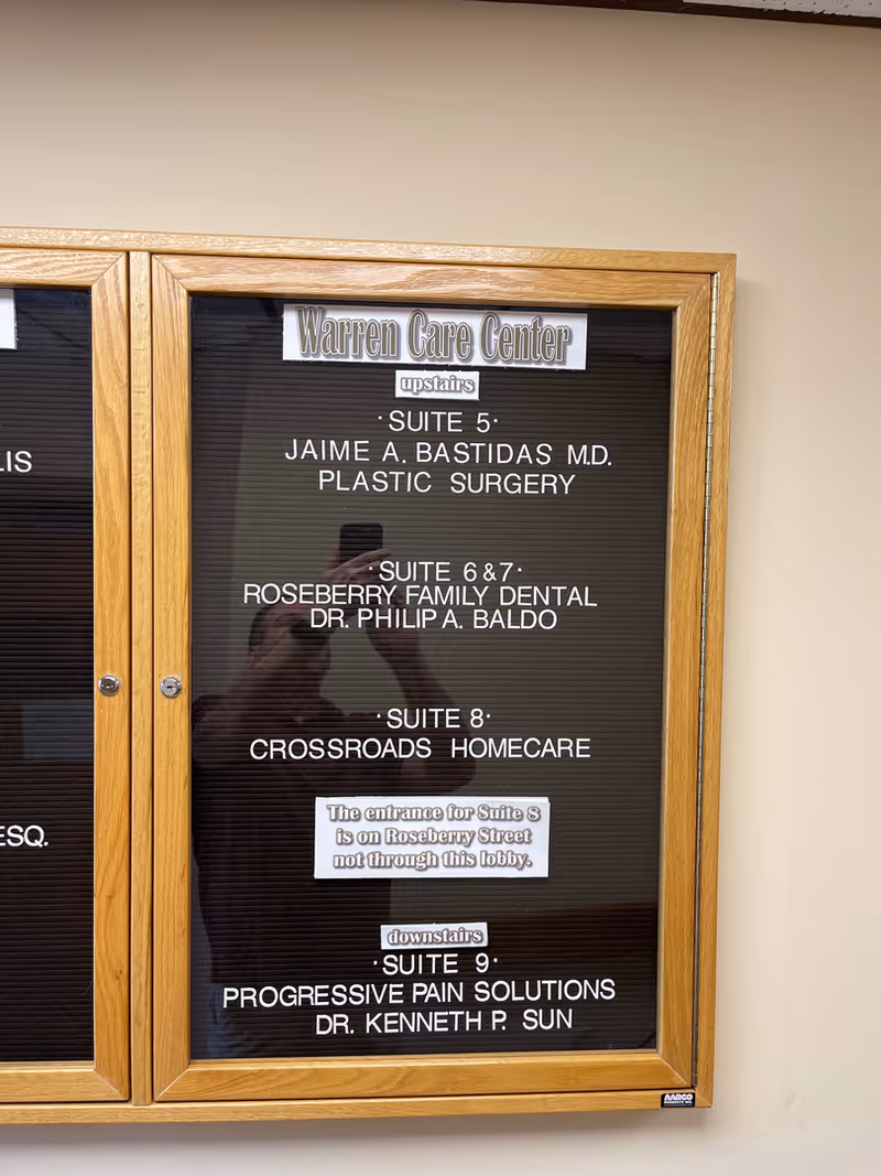 Wood-framed directory board displaying suite listings inside the Crossroads Homecare facility.