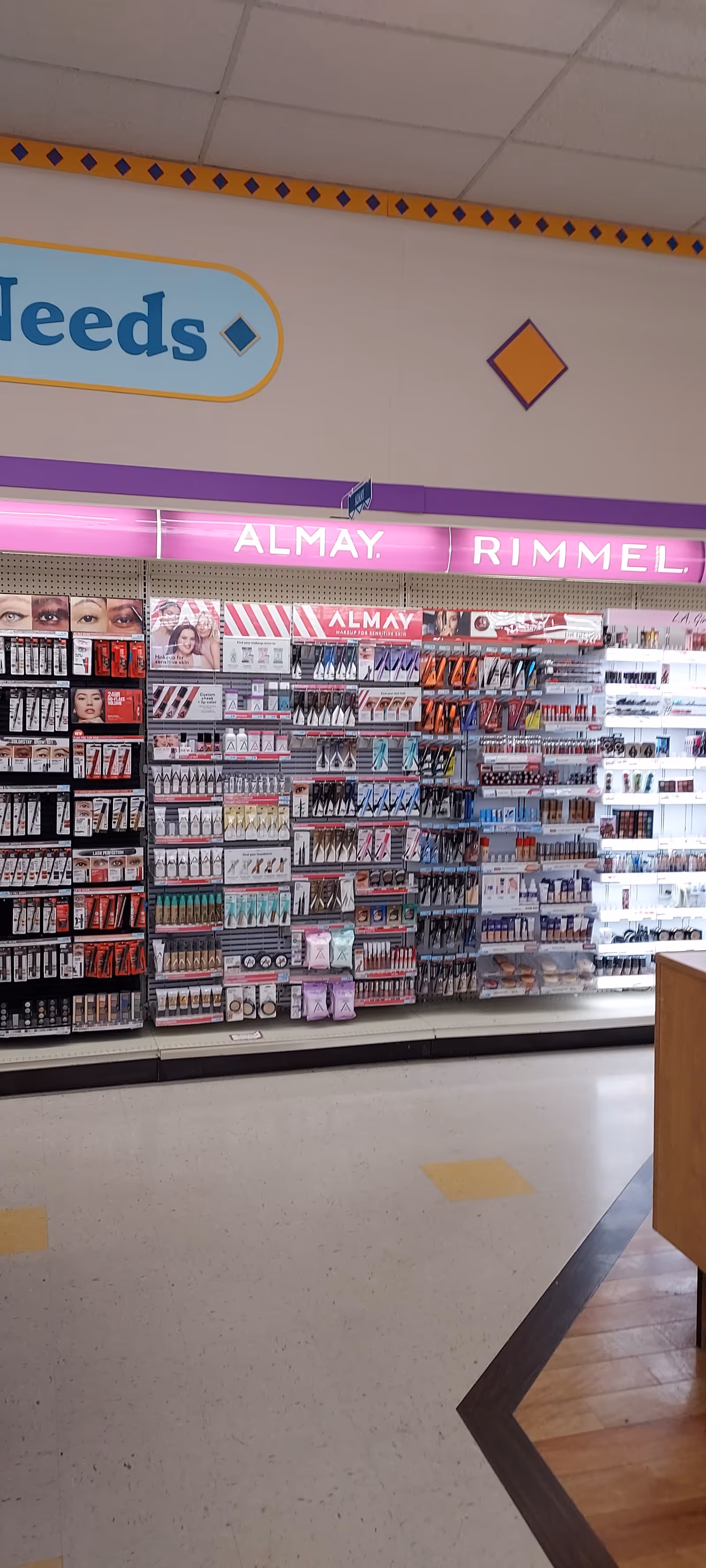 Inside a Discount Drug Mart aisle filled with makeup products on shelves.