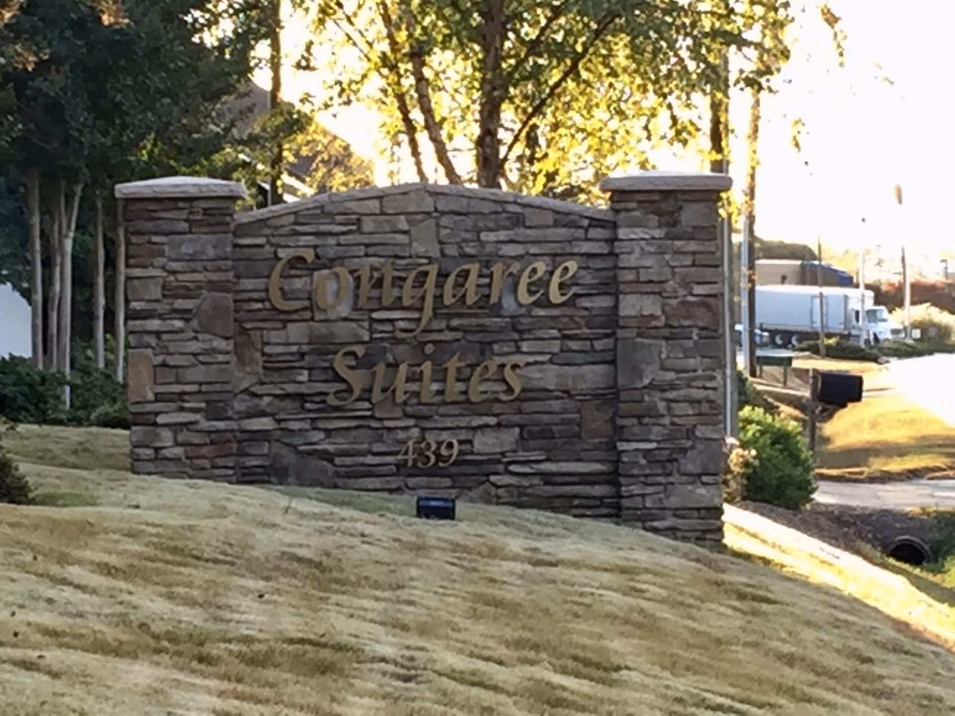 Stone entrance sign reads Cottage Suites with the number 439, outdoors.