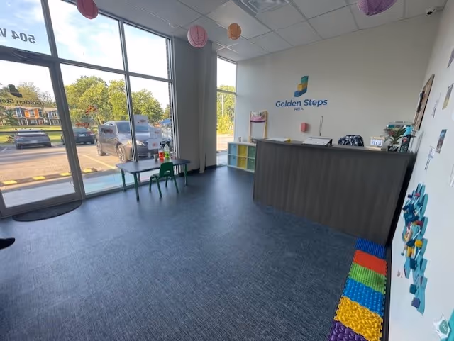 Reception area featuring Golden Steps ABA logo, large windows, and colorful decor.