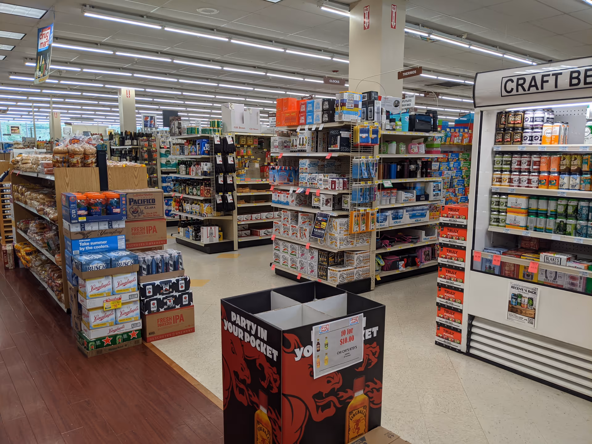 Grocery-style store interior with long aisles, shelves of items, and a central display.
