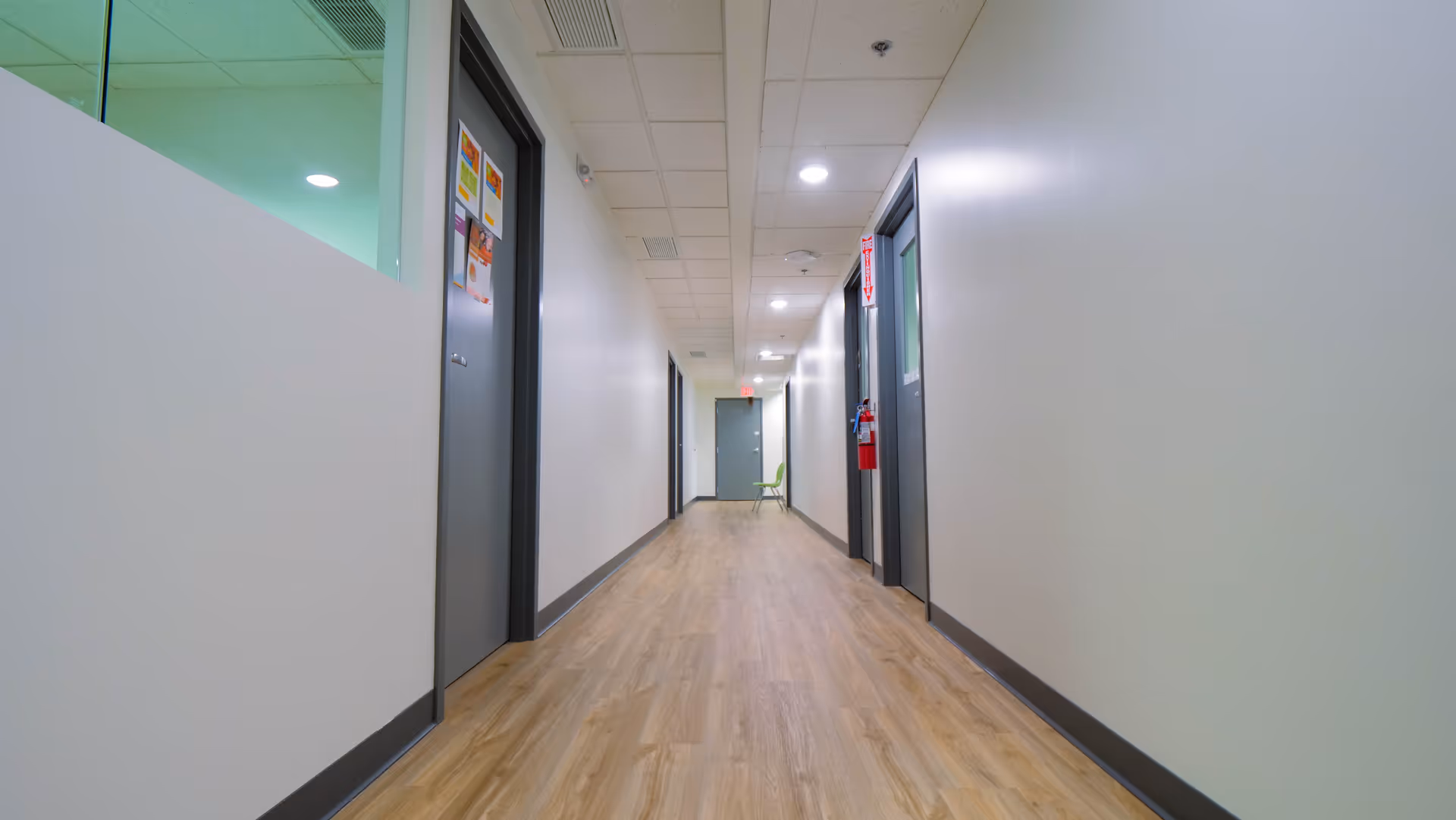 Long, empty hallway inside a senior living facility with doors on both sides.