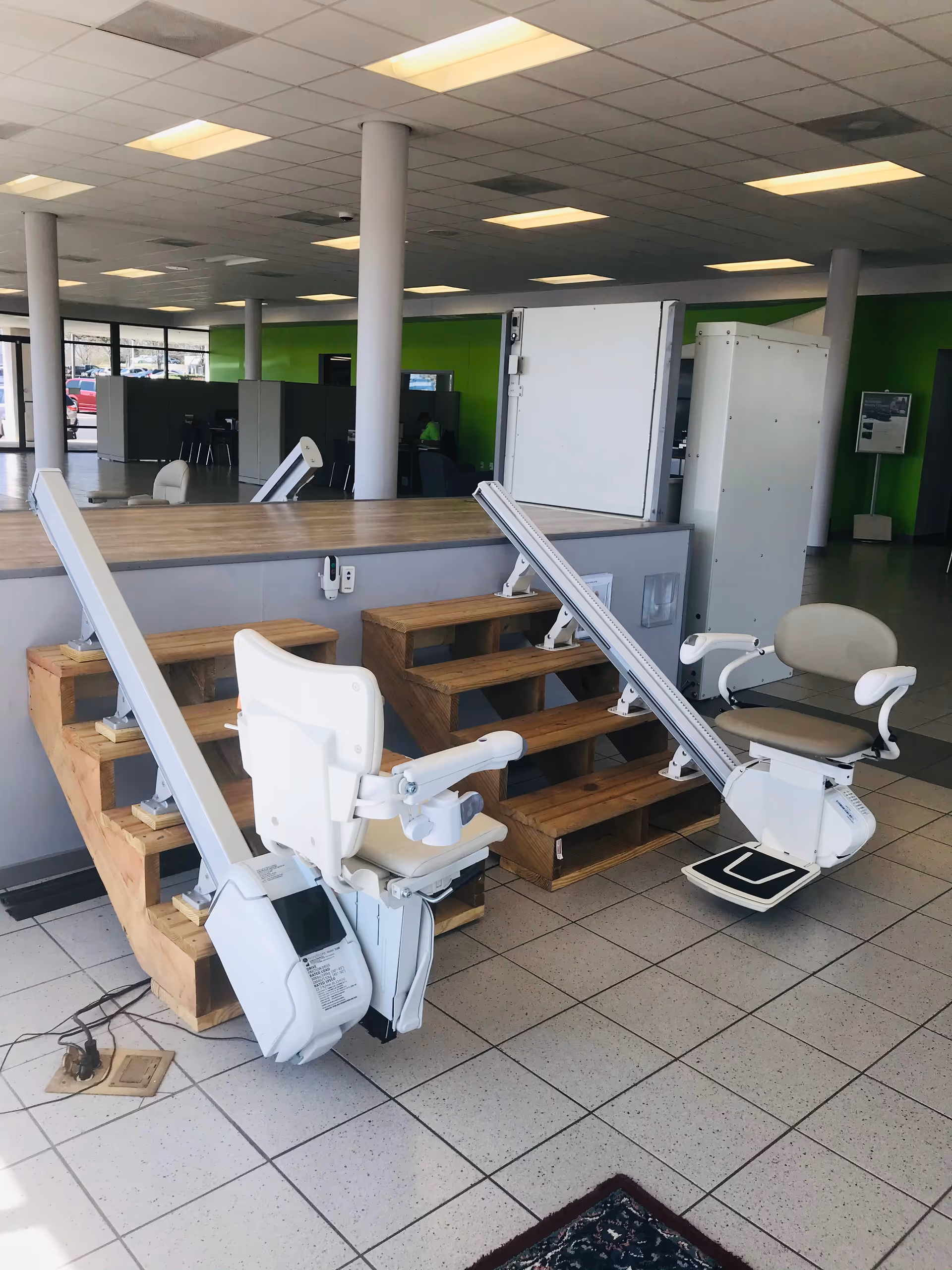 Interior scene with stair-step platform and mobility chairs in a facility showroom.
