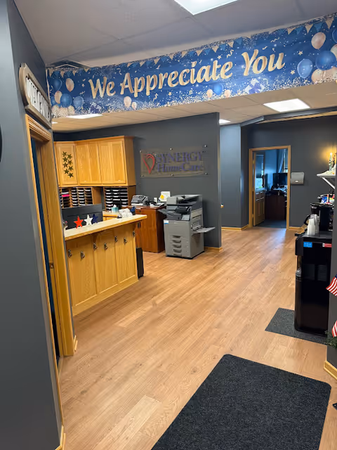 Reception area of a SYNERGY HomeCare facility with a We Appreciate You banner.
