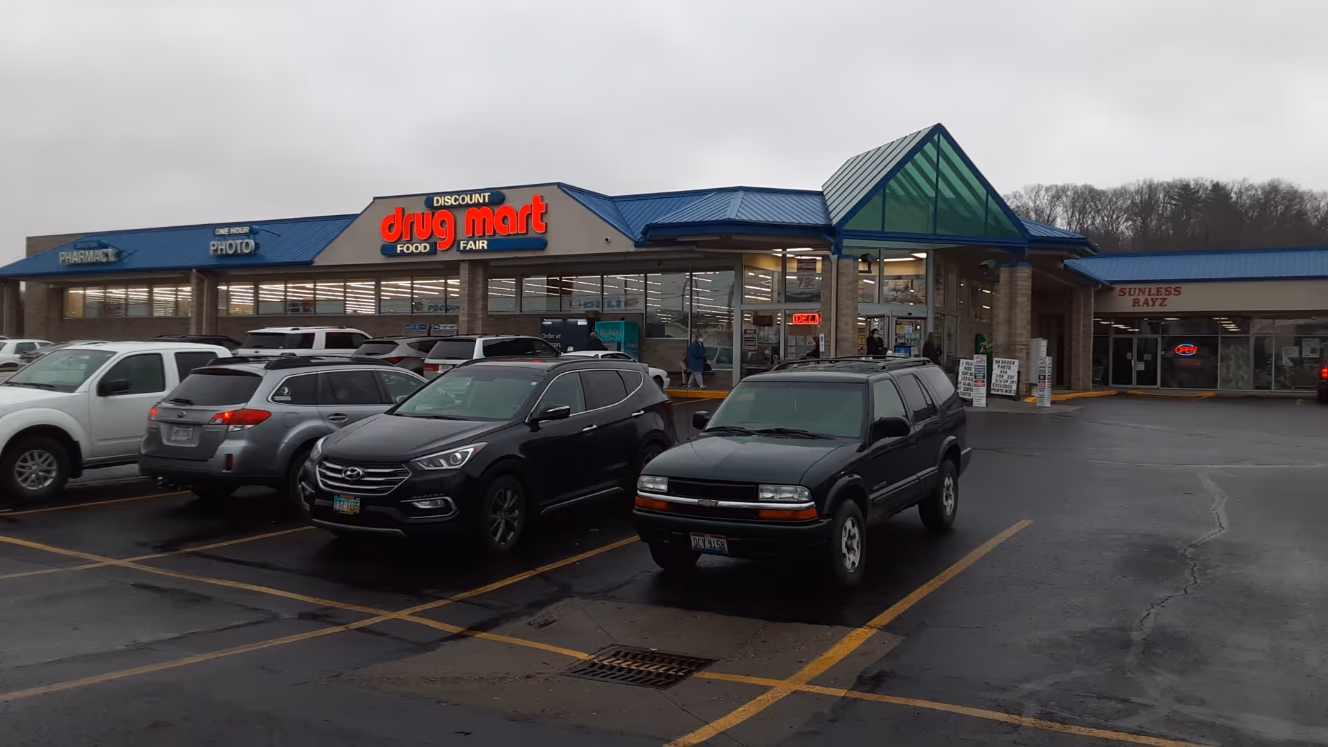 Exterior view of Discount Drug Mart storefront with a parking lot in front.