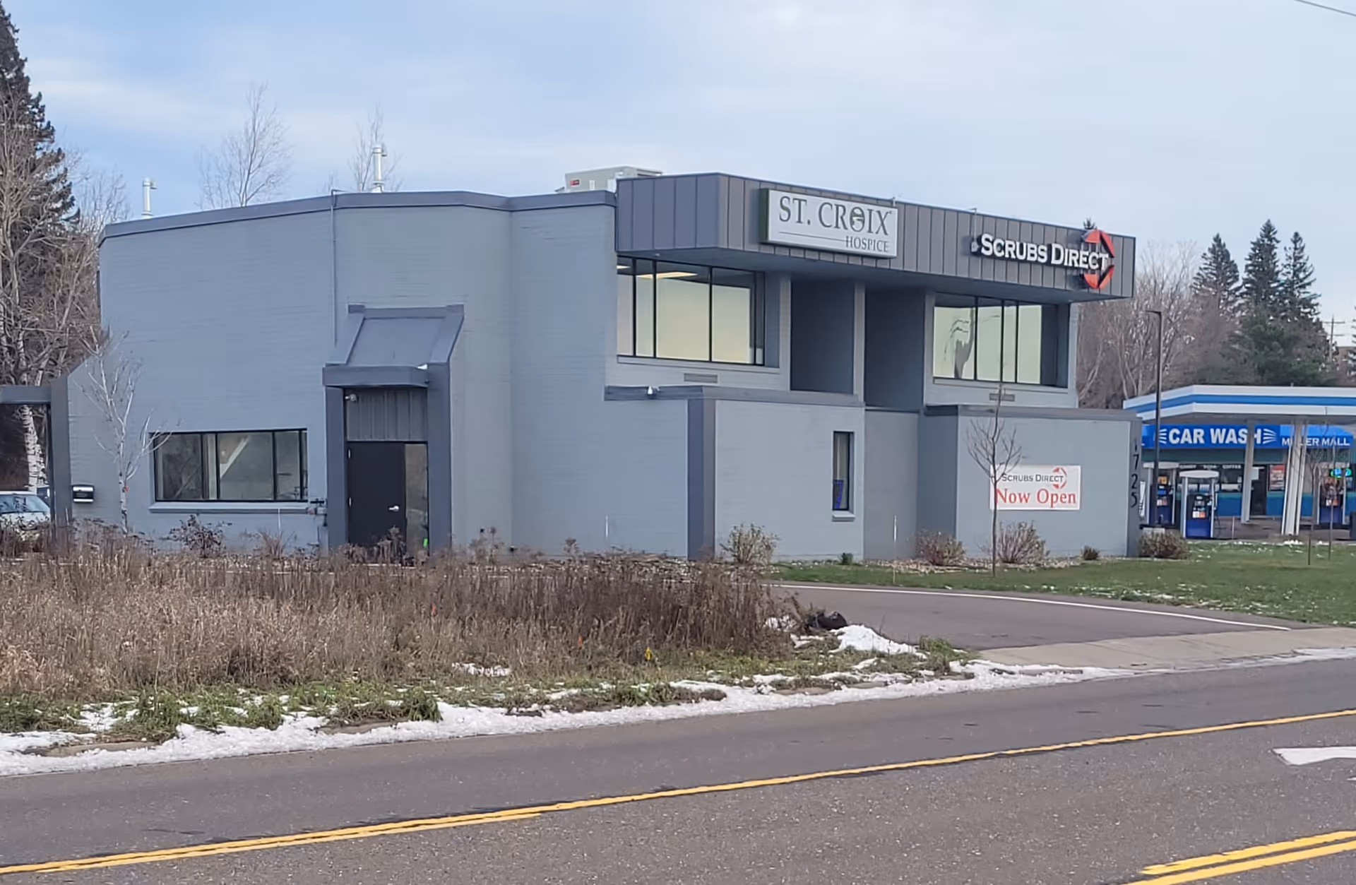 Exterior view of a gray St. Croix Hospice building with a street in front.