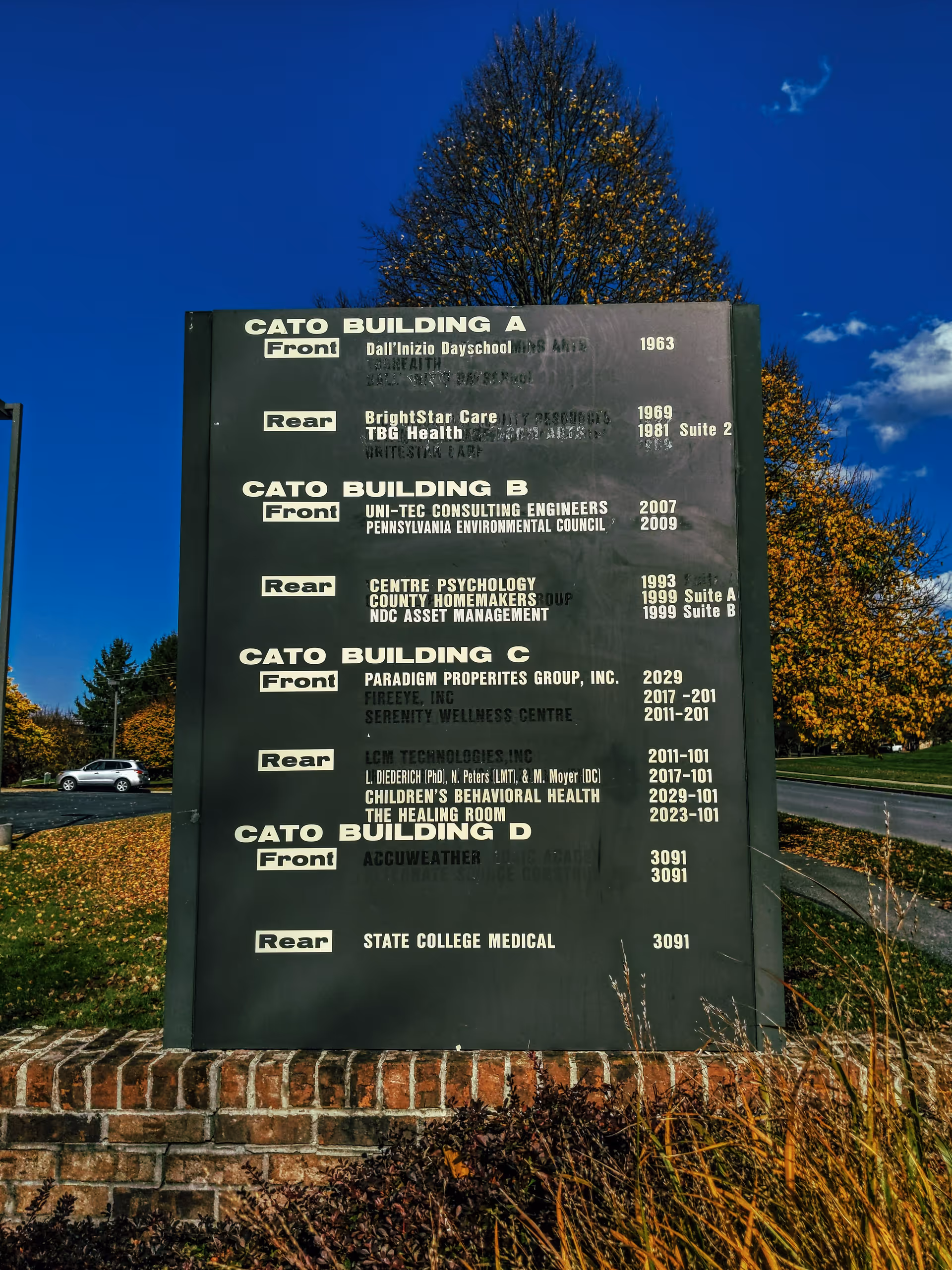 Large dark outdoor sign listing buildings with BrightStar Care branding