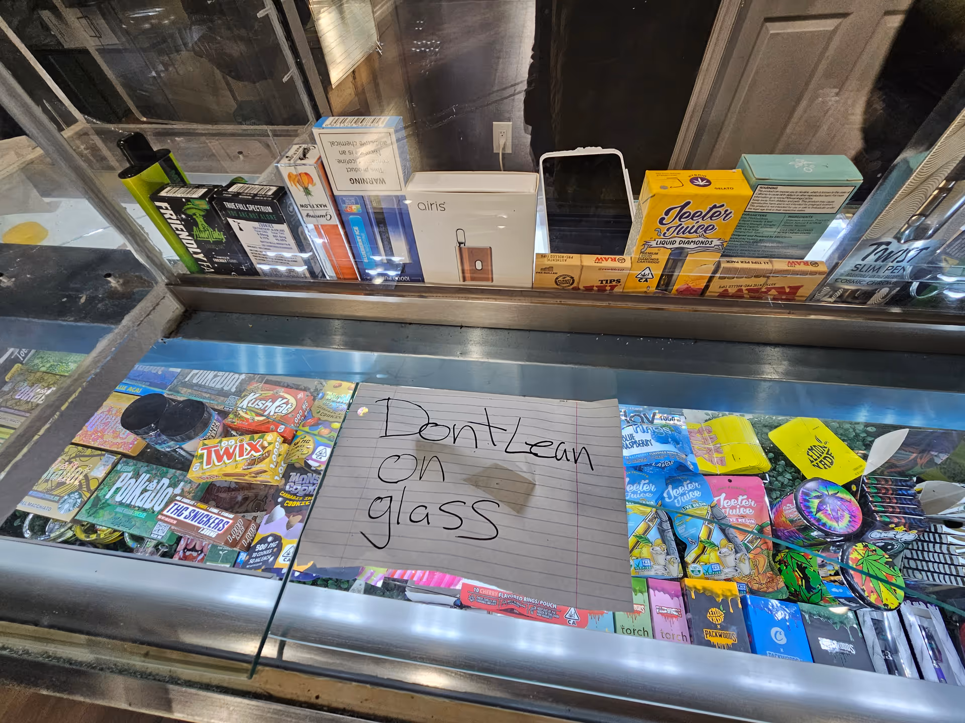 Glass display case filled with candy, snacks, and boxed merchandise.