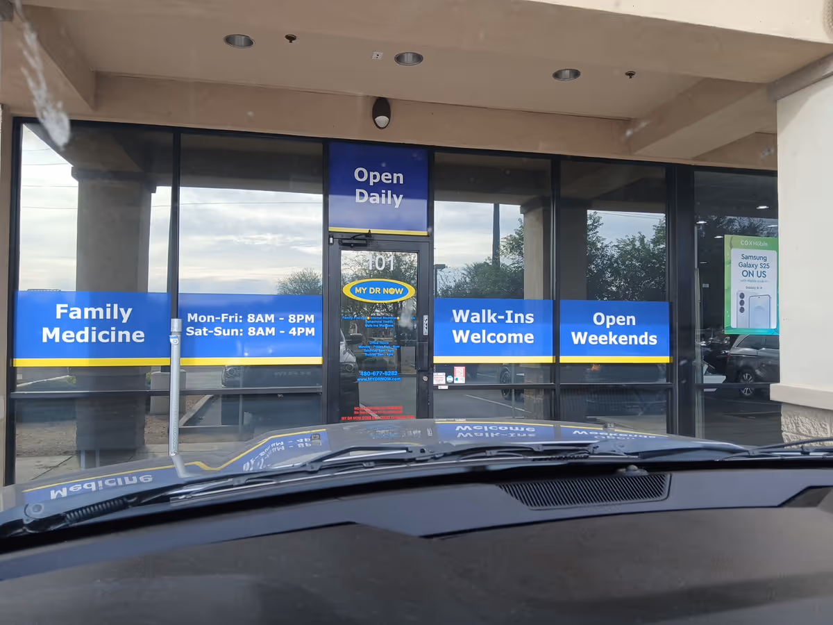 Exterior view of MY DR NOW clinic with blue signs on glass storefront.
