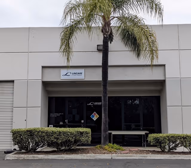 Exterior view of a Lincare facility entrance with a palm tree and glass doors.