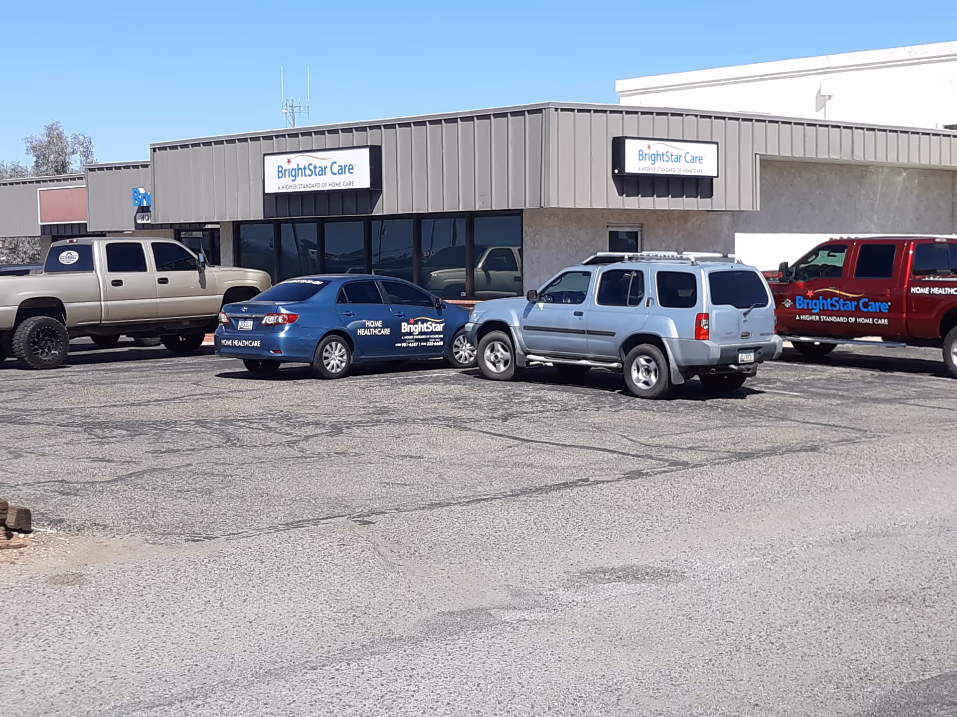 BrightStar Care building storefront with several parked vehicles in a gravel lot
