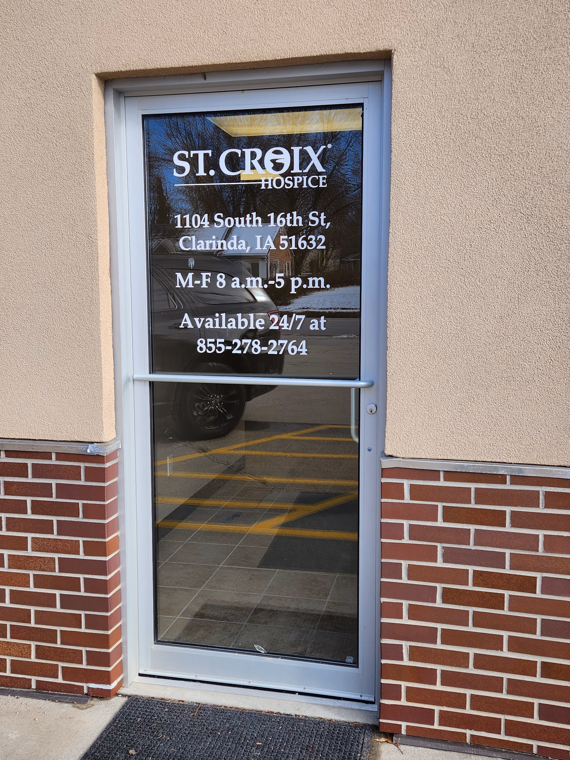 Glass entry door with St. Croix Hospice signage and brick exterior of building