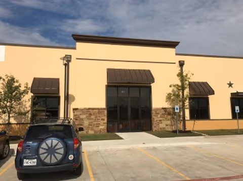 Front exterior of Enhabit Home Health facility with parking lot in view.