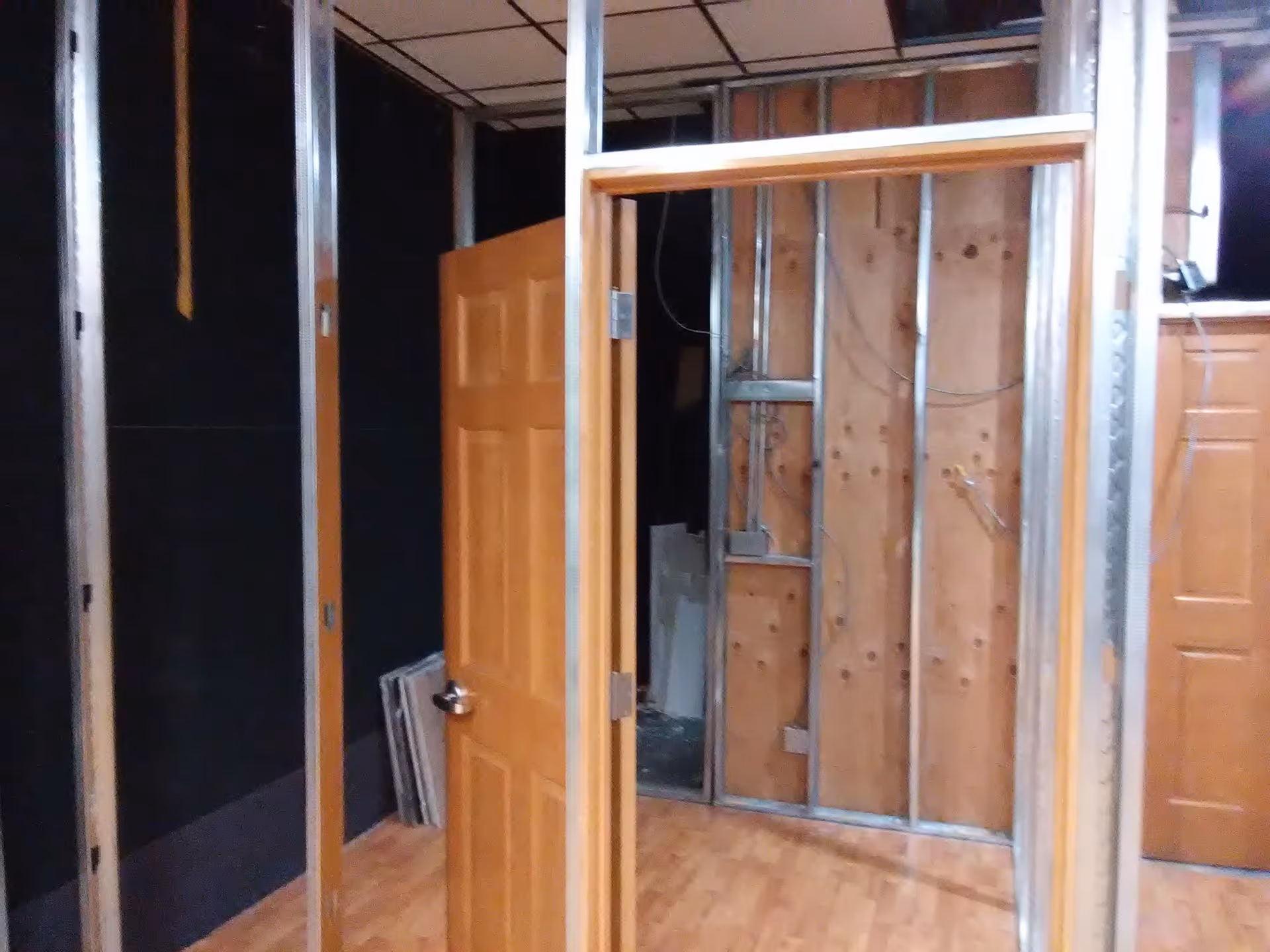 Unfinished interior with exposed metal studs, framing, and a doorway in construction