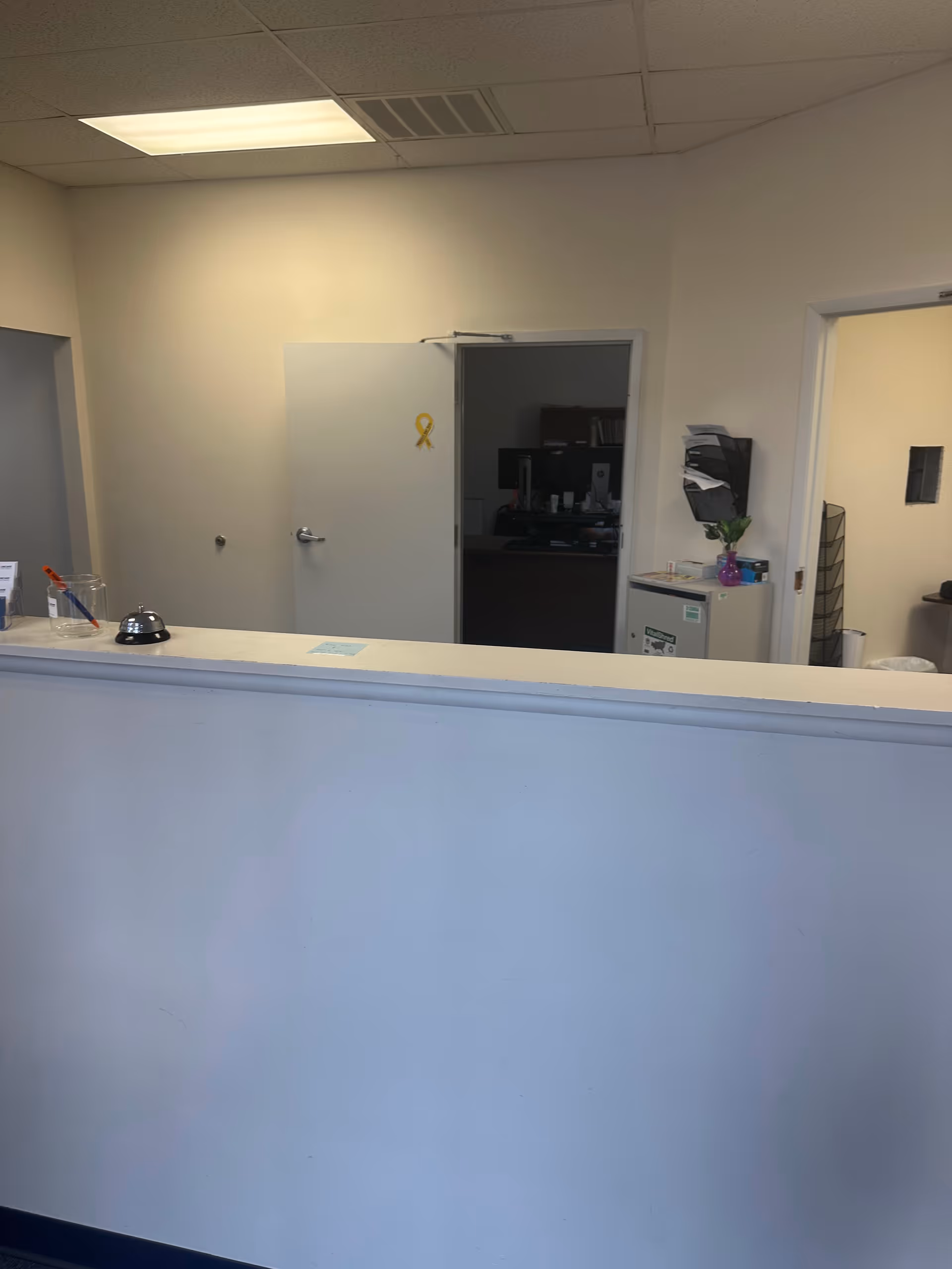 Reception desk in a LINCARE facility lobby with doors and office equipment.
