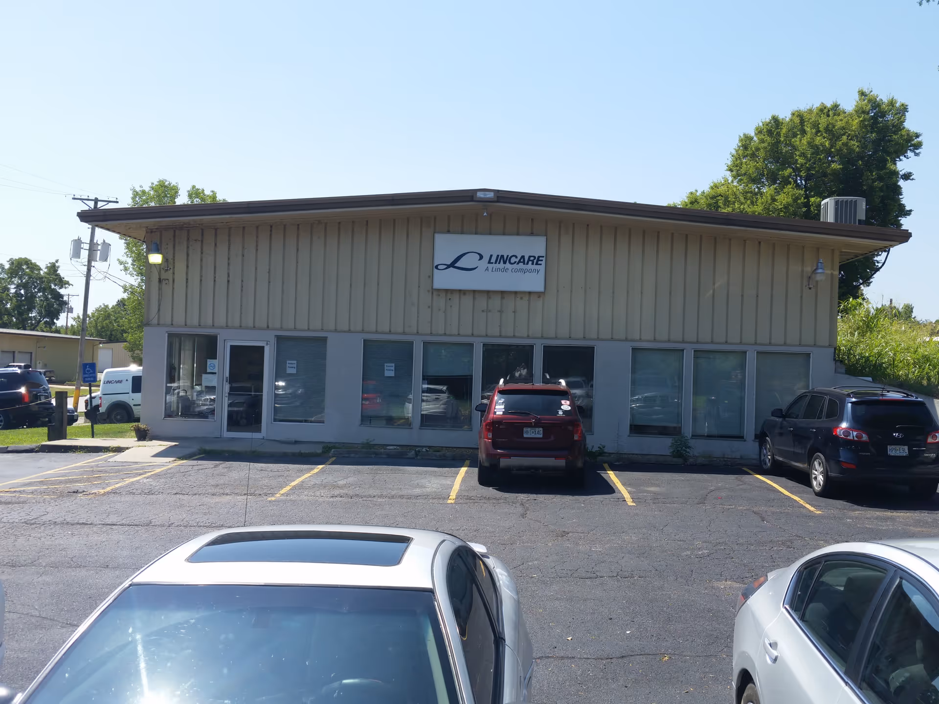 Front view of a LINCARE facility with parking and glass storefront windows.