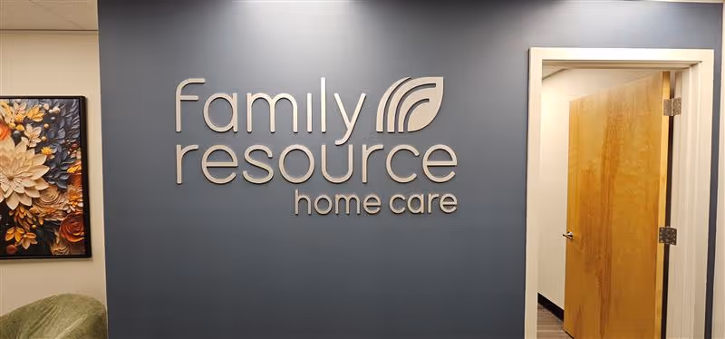 Interior lobby area featuring a blue wall with Family Resource Home Care logo and open door