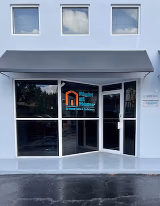 Front entrance of a Right at Home senior facility with glass doors and a dark awning.
