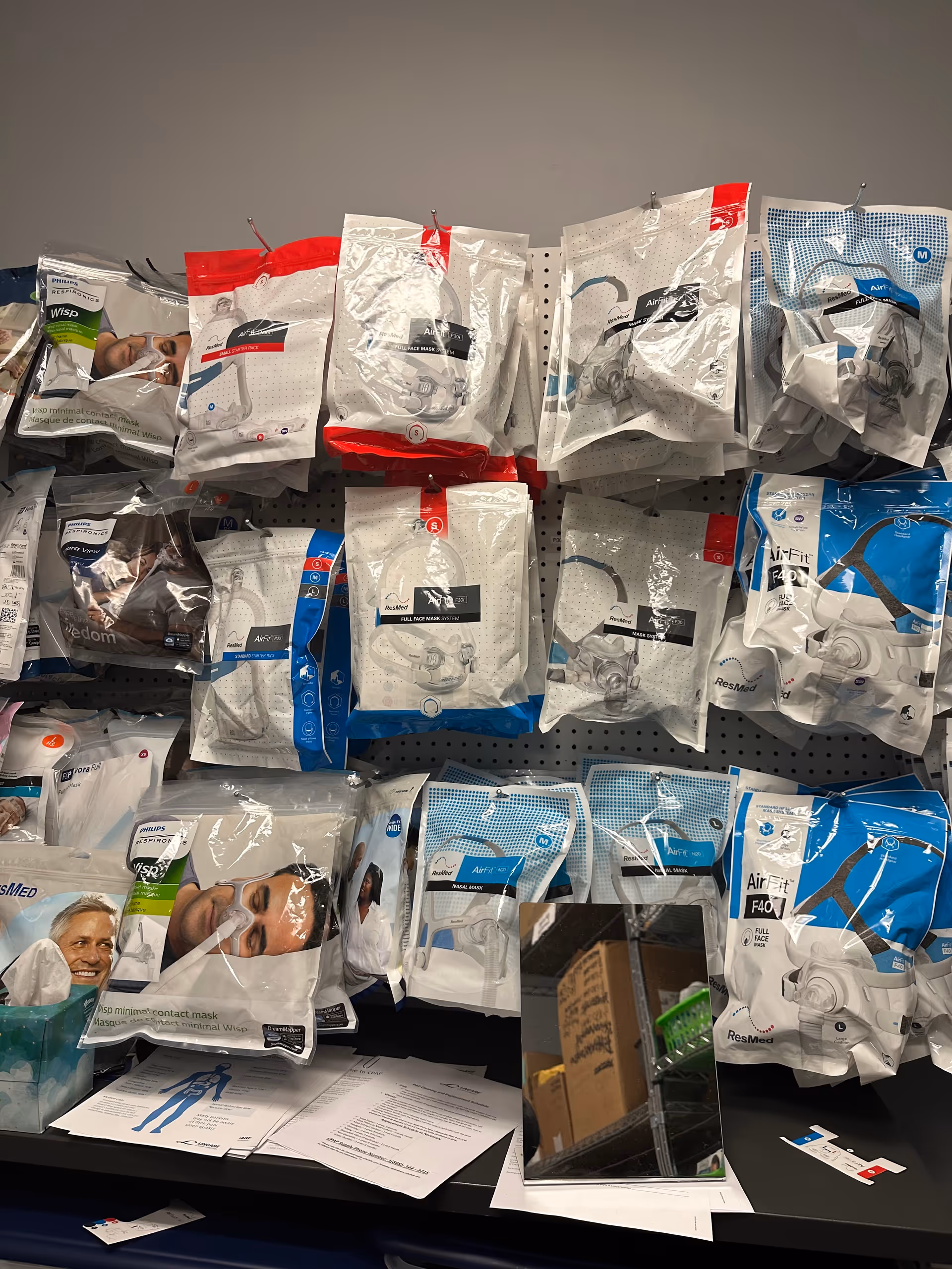 Shelves filled with packaged face masks and medical supplies in a clinic-like room