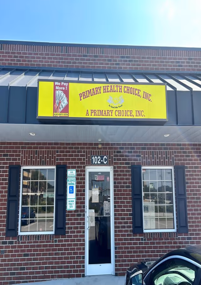 Brick storefront with a bright yellow Primary Health Choice sign above entrance and windows.