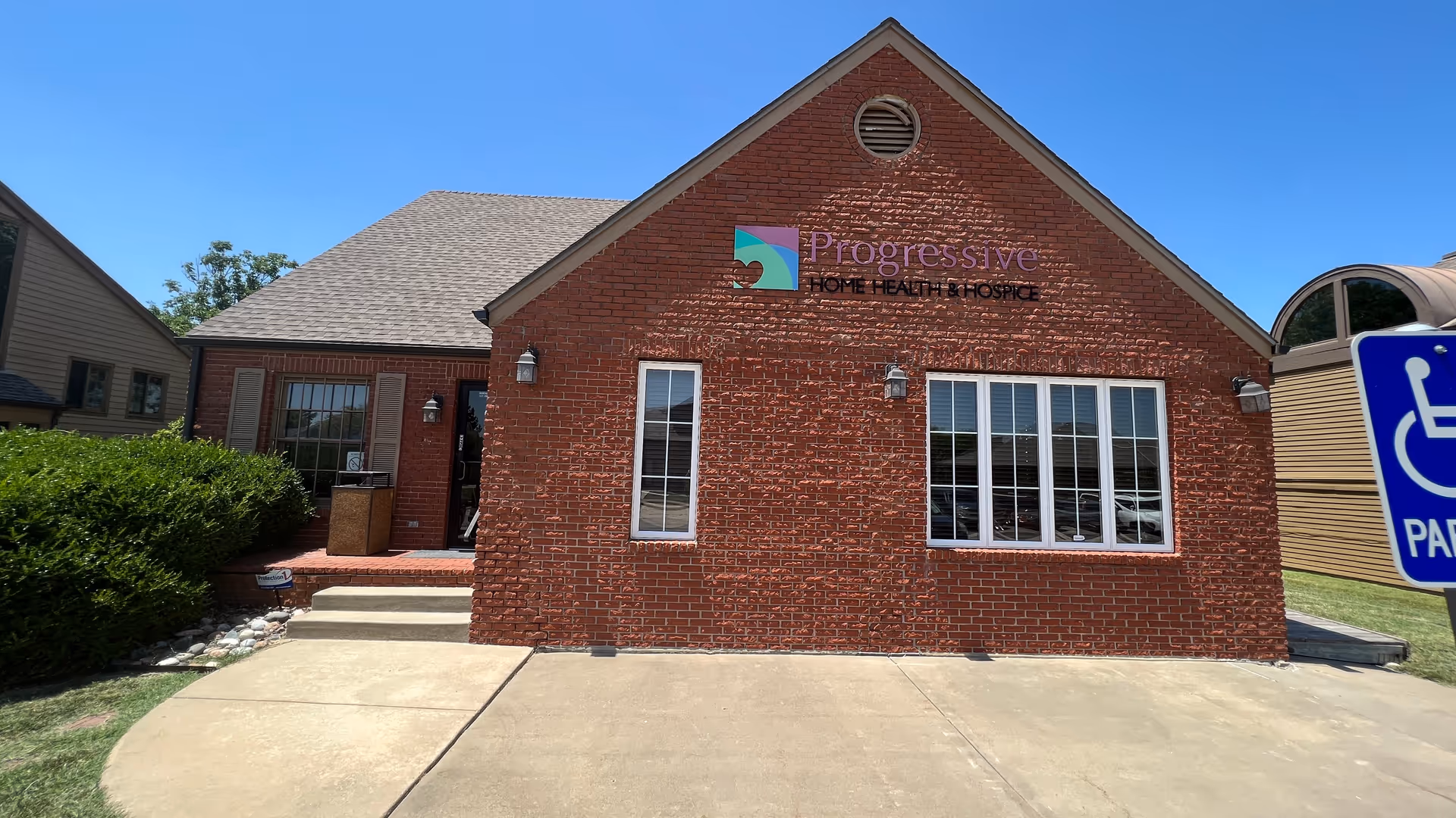 Brick building with Progressive Home Health & Hospice sign and large front windows.