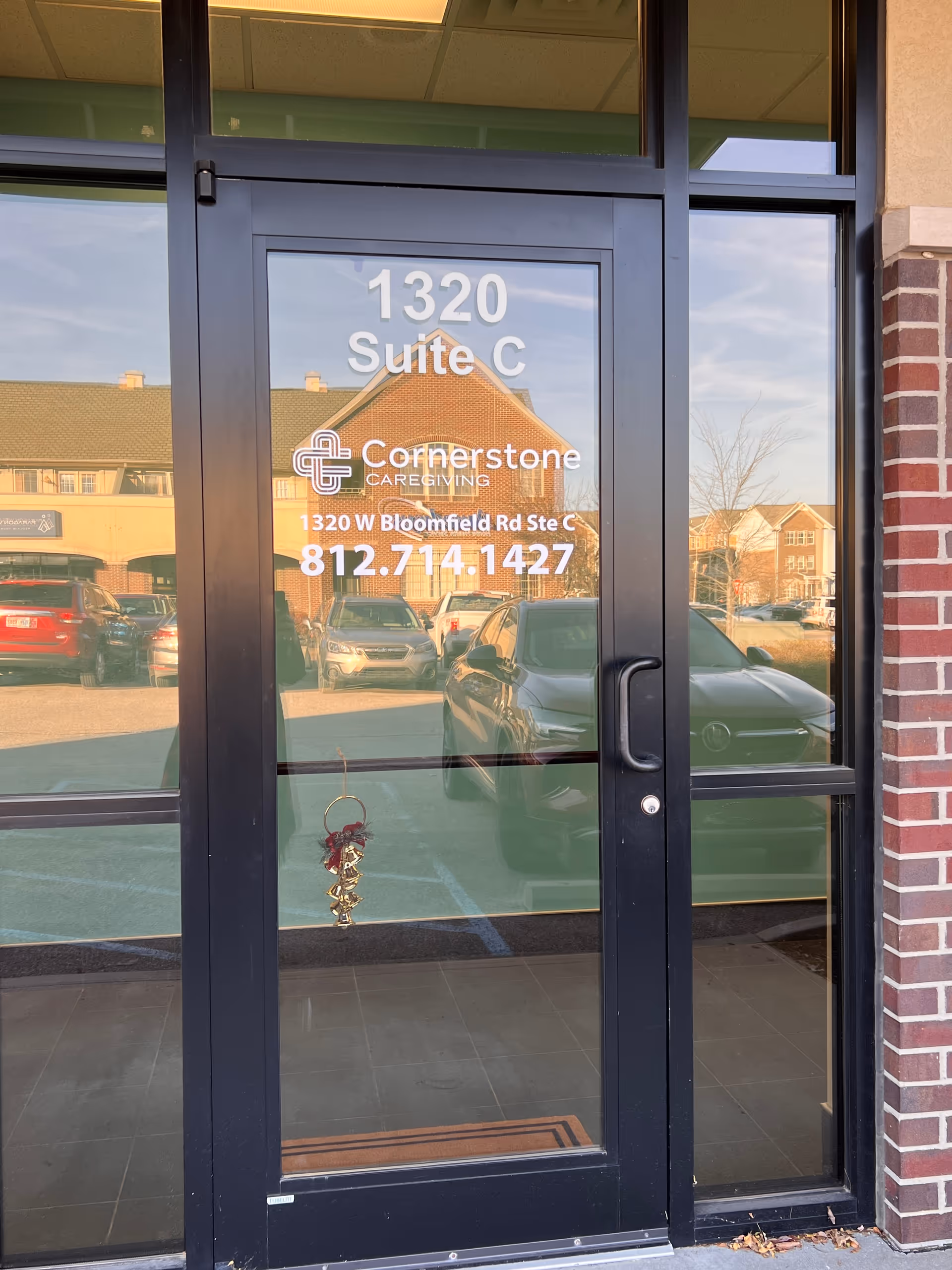 Glass door entrance to Cornerstone Caregiving, Suite C, with address and phone number.