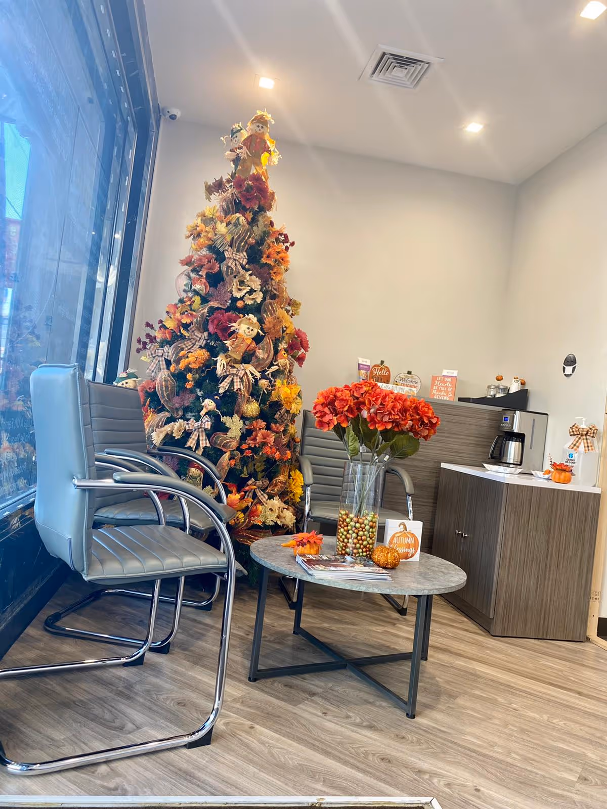 Holiday-decorated lounge with a Christmas tree, red flowers, and coffee station.