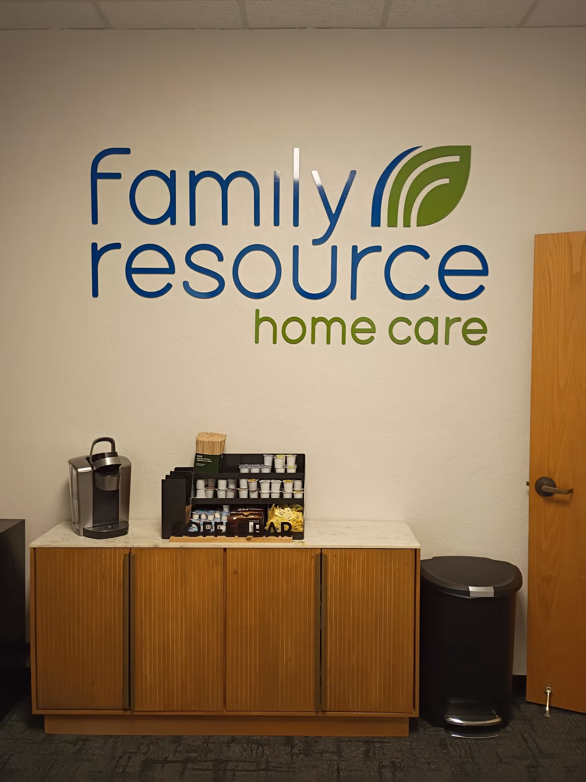 Interior office area with a wall sign reading Family Resource Home Care and a coffee bar.