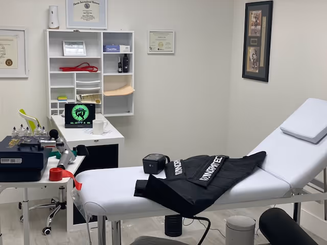 Reload Physical Therapy clinic room with a white treatment bed and medical equipment.