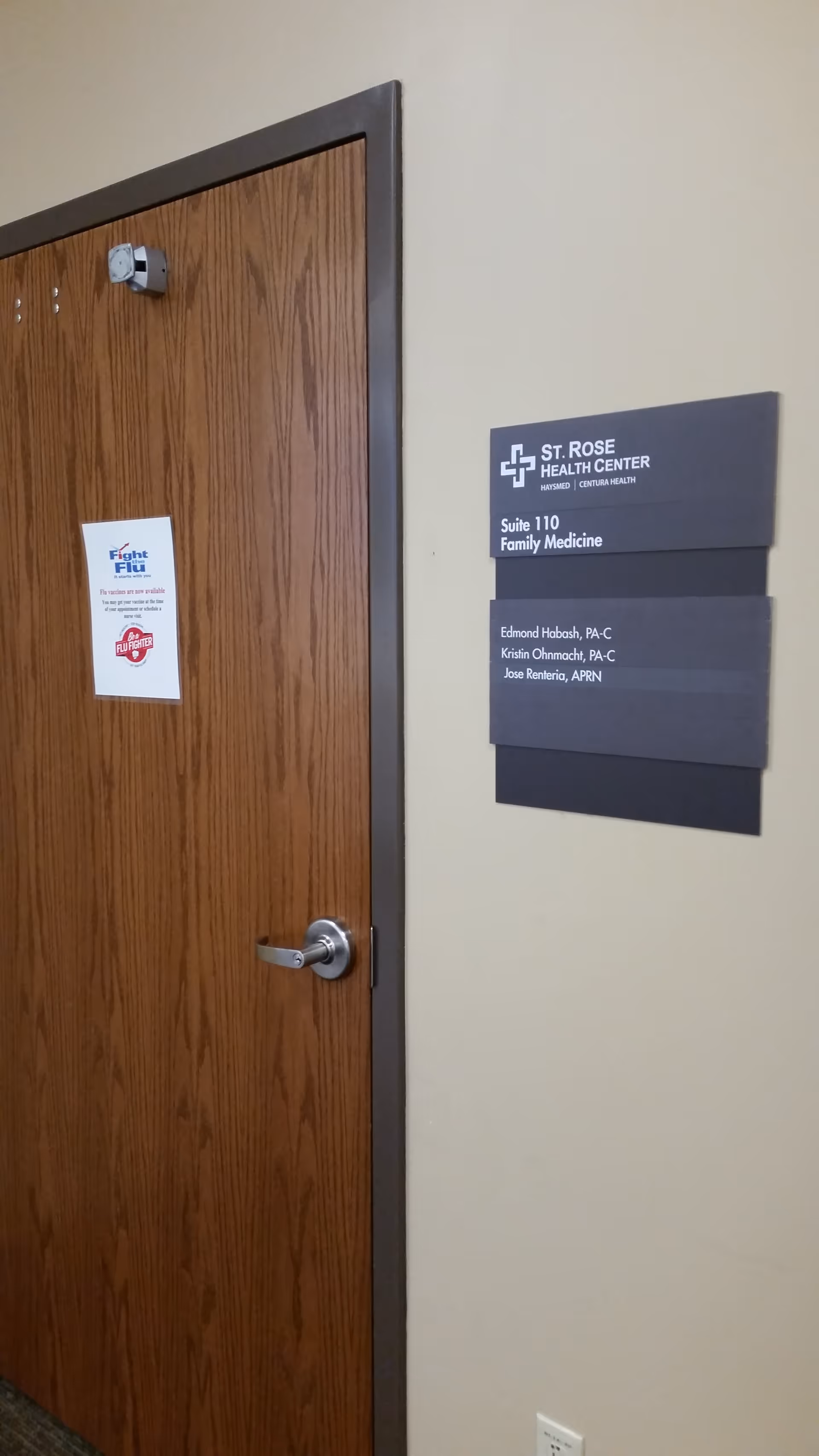 Interior hallway with a wooden door and a St. Rose Health Center suite plaque.