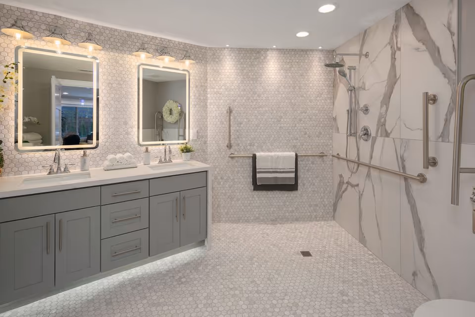 Ashford at Firdale Village bathroom with double vanity, tile walls, and accessible shower.
